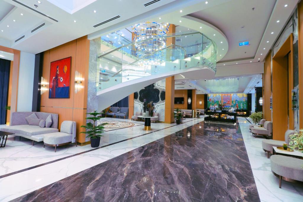 een lobby van een hotel met een grote roltrap bij The Rumi Hotel & Residences in Doesjanbe