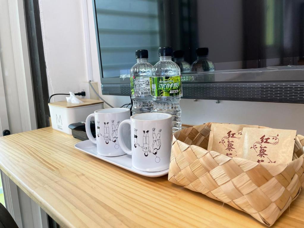 una mesa con dos tazas y dos botellas de agua en Lao Fan Home en An-shuo