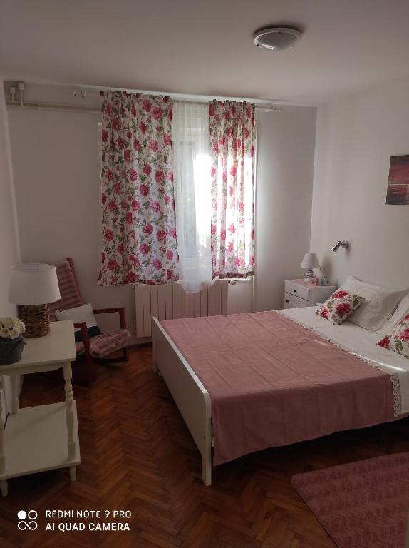 1 dormitorio con 1 cama y 2 ventanas con cortinas en Kuća za odmor MANA, en Lun