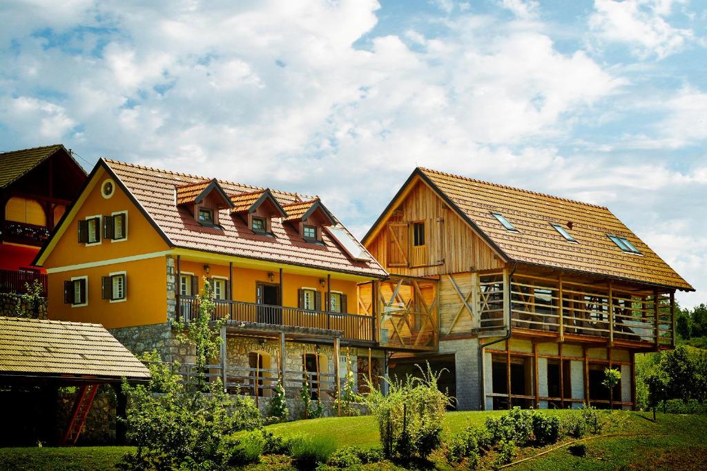 una gran casa amarilla con techo en Guest House Kalska Domačija, en Semič