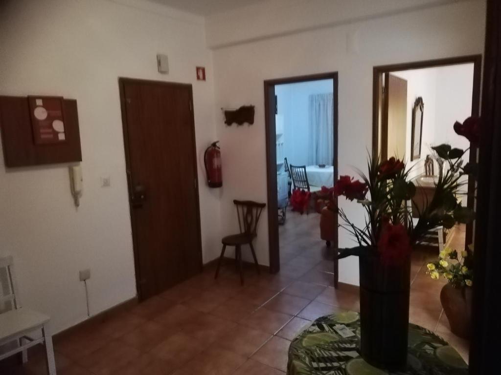 a living room with a vase of flowers on a table at Apartamento Tiago in Sines