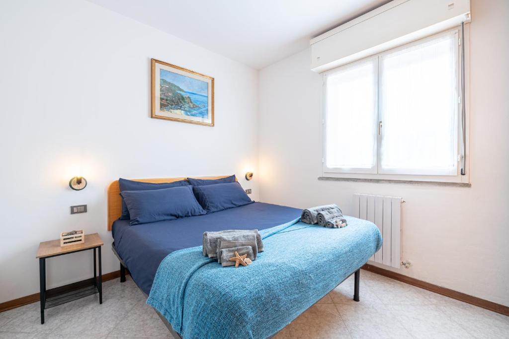 Un dormitorio con una cama azul y una ventana en Casa Rinalmas FREE PARKING & WIFI, en Castiglione della Pescaia