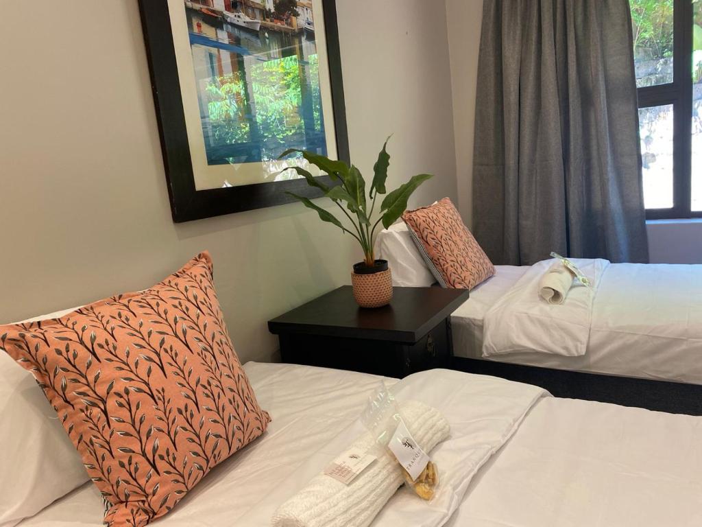 een hotelkamer met twee bedden en een plant bij Tranquility in Margate