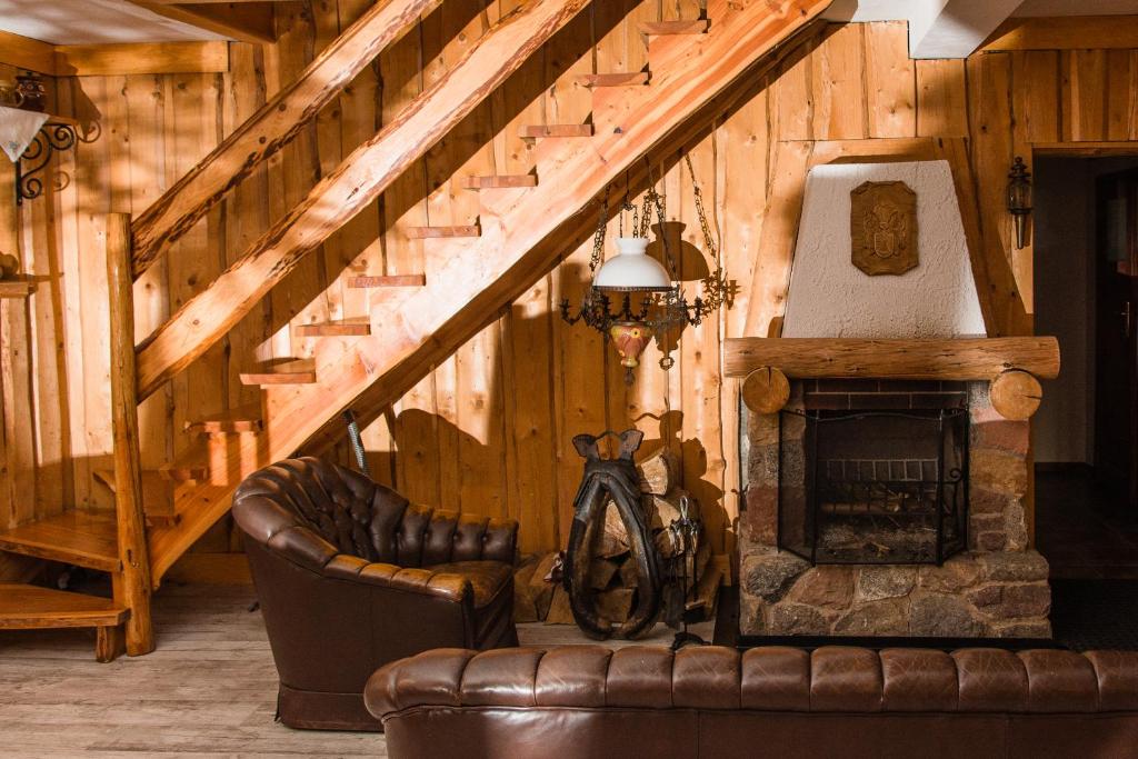 a living room with a couch and a fireplace at Leśna Zagroda in Parchowo