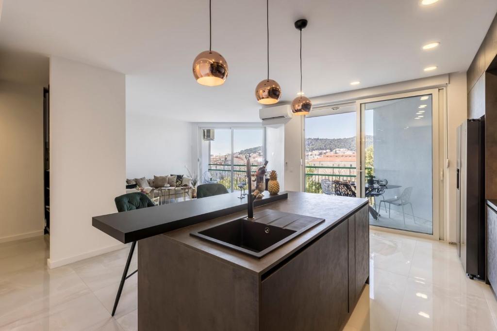 eine Küche mit Spüle und ein Wohnzimmer in der Unterkunft Carmen - Luxury 2-Bedroom Apartment - Downtown in Split