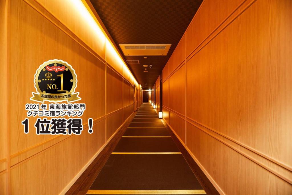 a long hallway with a sign on the wall at Ikeda Onsen Ryokan Tachikawa in Ogaki