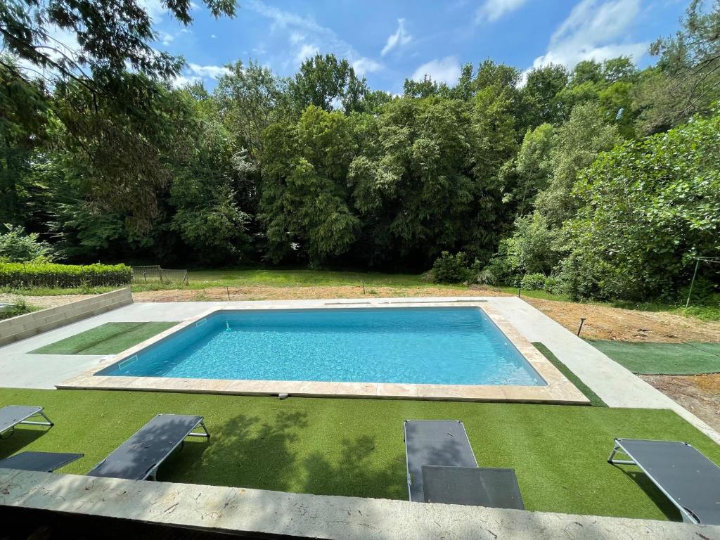 una piscina en un patio con árboles en Résidence Les Milandes, en Cazaubon