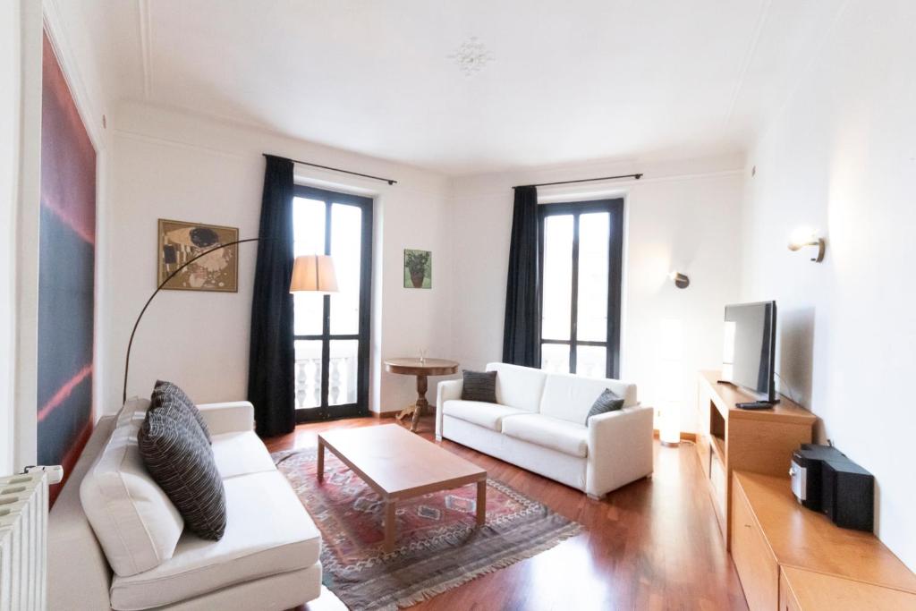a living room with two white couches and a tv at Washington Apartment in Milan