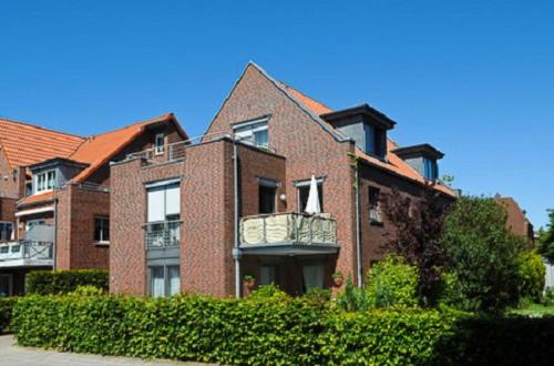 a brick house with a balcony on the side of it at Ferienwohnung Riegstra in Esens