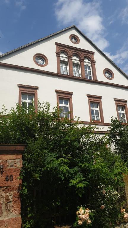ein weißes Gebäude mit einer Uhr darauf in der Unterkunft Gwuni's Farm in Geithain