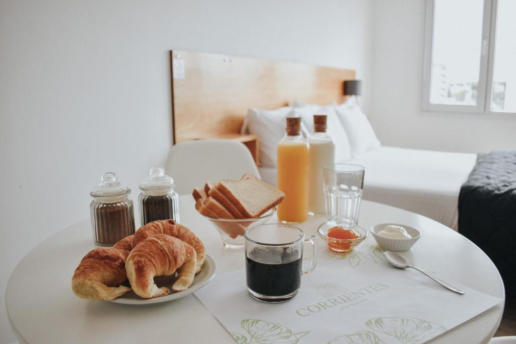a table topped with a plate of croissants and toast at Corrientes Premium con desayuno in Bahía Blanca