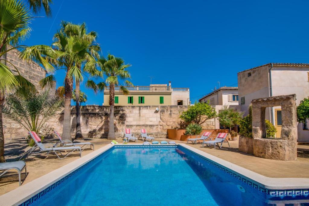 a swimming pool with chairs and a house in the background at Ideal Property Mallorca - Verdera in Maria de la Salut