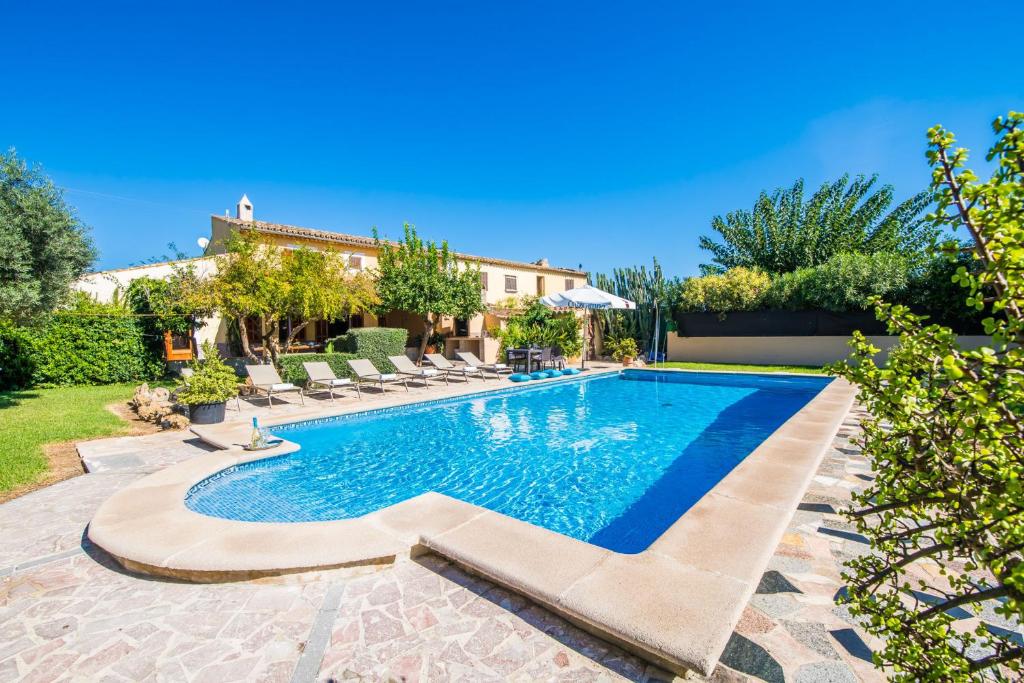 een zwembad in een achtertuin met stoelen en een huis bij Ideal Property Mallorca - Verga in Pollença