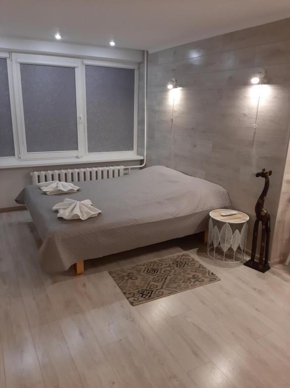 1 dormitorio con cama, ventana y alfombra en Asimarė, en Vilna