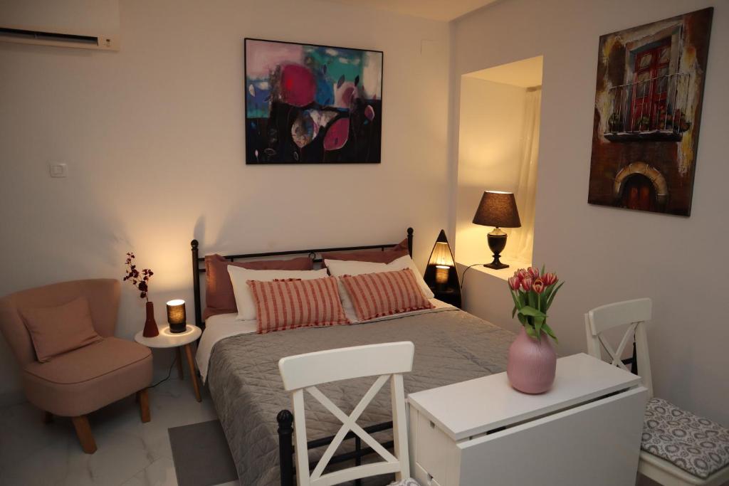 a bedroom with a bed and a chair and a table at "Art Studio" Old Town Rovinj-Holiday in Rovinj