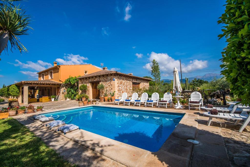 a swimming pool with chairs and a house at Ideal Property Mallorca - Villa Erika in Inca