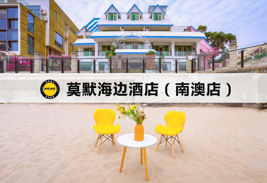 2 chaises et une table avec un vase sur une plage dans l'établissement Momo Seaside Hotel - Shenzhen Nanao, à Dapengcheng