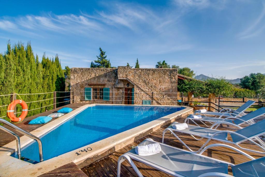 an outdoor swimming pool with chairs and a swimming poolvisor at Ideal Property Mallorca - Sa Vinya Vella in Alcudia