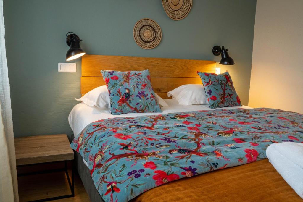 1 dormitorio con 1 cama grande y edredón colorido en Logis Hôtels - Le Belvédère - Hôtel 2 étoiles et Restaurant, en Rocamadour