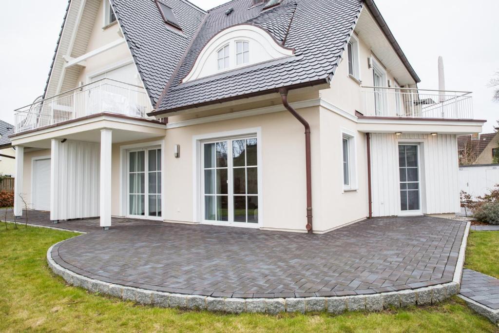 a white house with a circular driveway at Ferienwohnung Duene 2_2 in Groß Kirr
