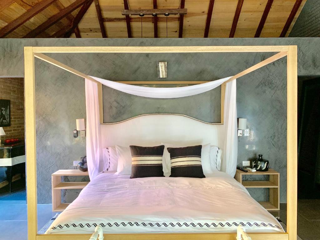 a bedroom with a canopy bed with black pillows at Bendita Luna in Zipolite