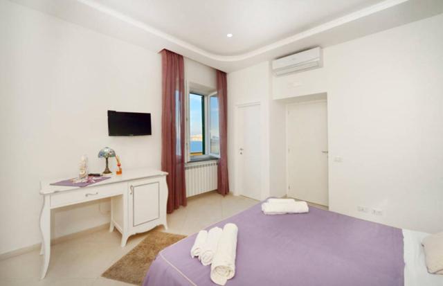 a white room with a bed and a desk and a sink at Terra Murata Boutique b&b in Procida