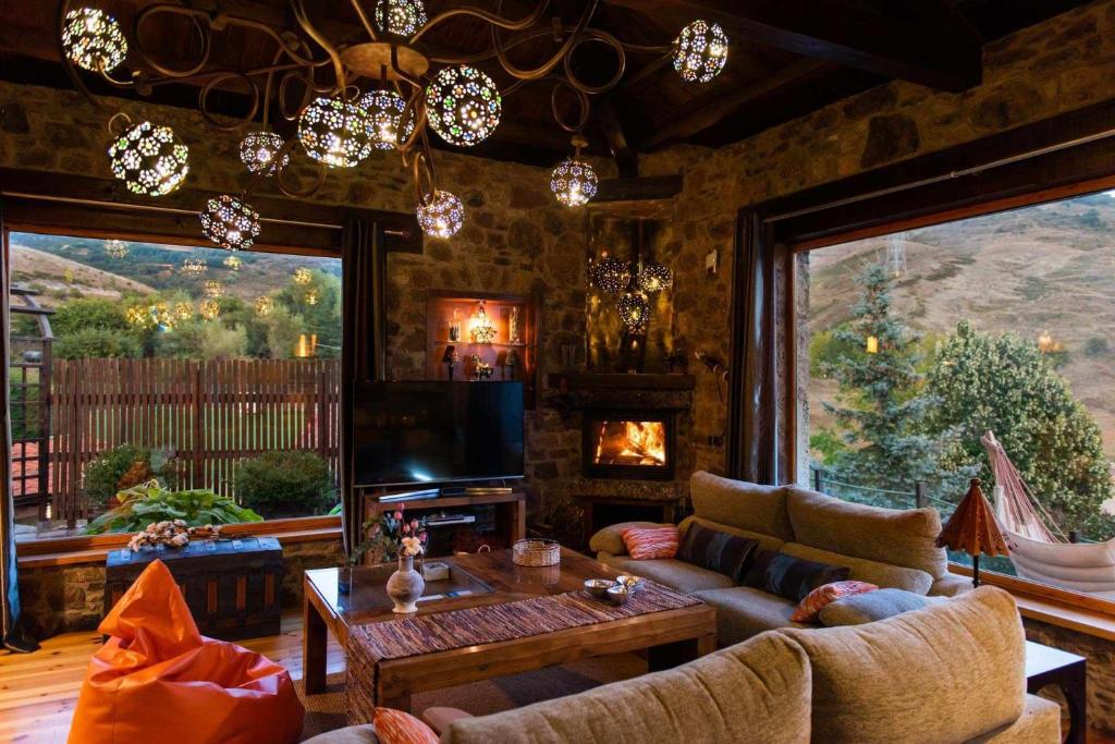 sala de estar con sofá, TV y chimenea en Loft de montaña en Buiza