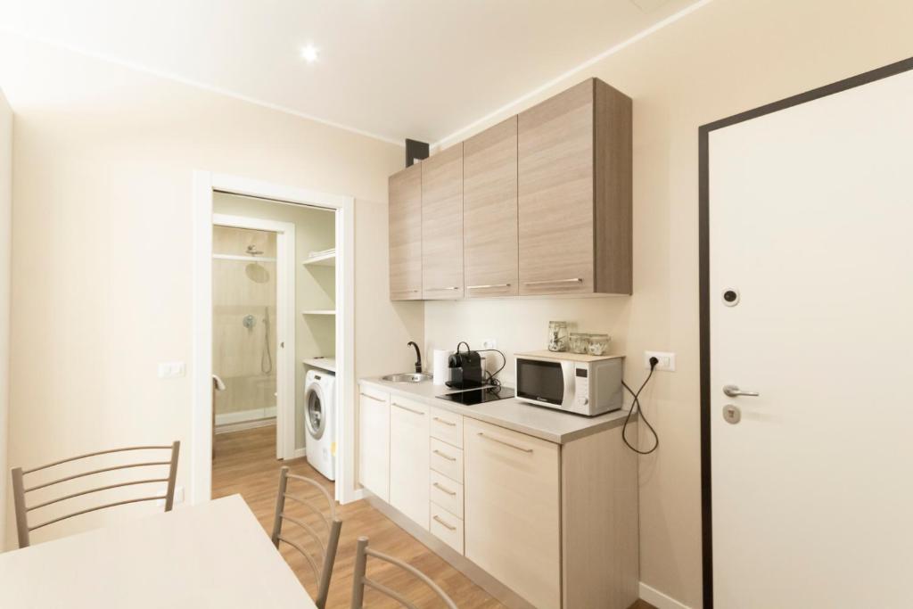 kuchnia z białymi szafkami i mikrofalówką w obiekcie Via Torino Apartment 3 w Mediolanie