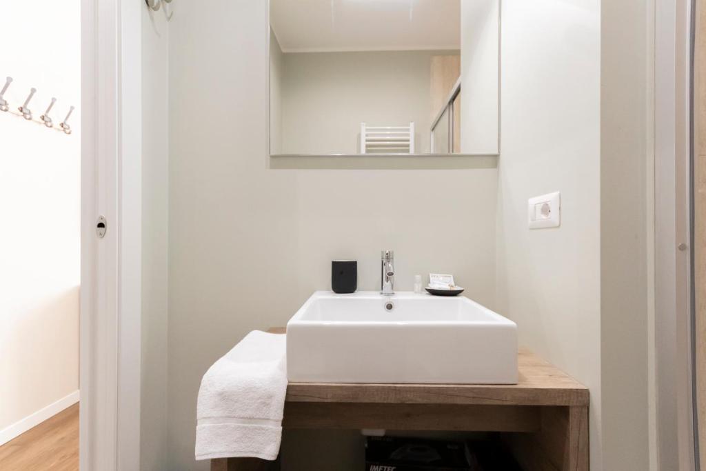 łazienka z białą umywalką i lustrem w obiekcie Via Torino Apartment 3 w Mediolanie