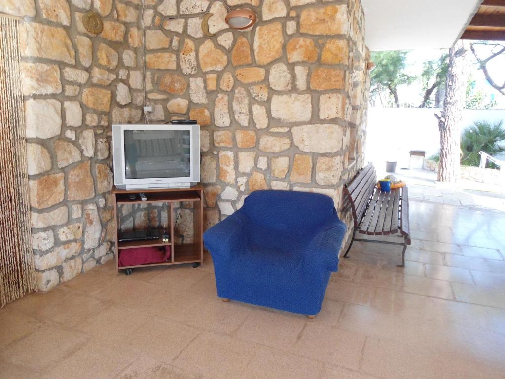 a living room with a tv and a blue chair at Ville Alba & Azzurra in Polignano a Mare