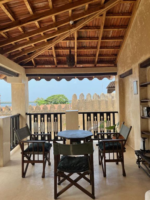 una sala da pranzo con tavolo e sedie su un balcone di Subira House a Lamu