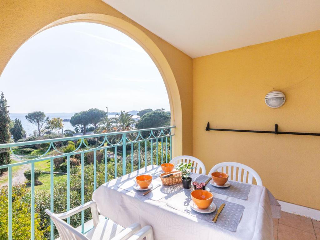 a table and chairs on a balcony with a window at Apartment Les Calanques Thalasso Thérapie by Interhome in Les Issambres