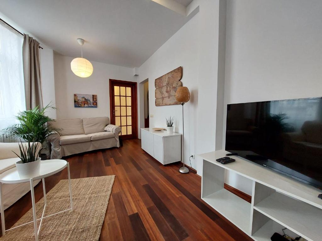 a living room with a large flat screen tv at Sweet Dreams Suites Cismigiu Gardens in Bucharest