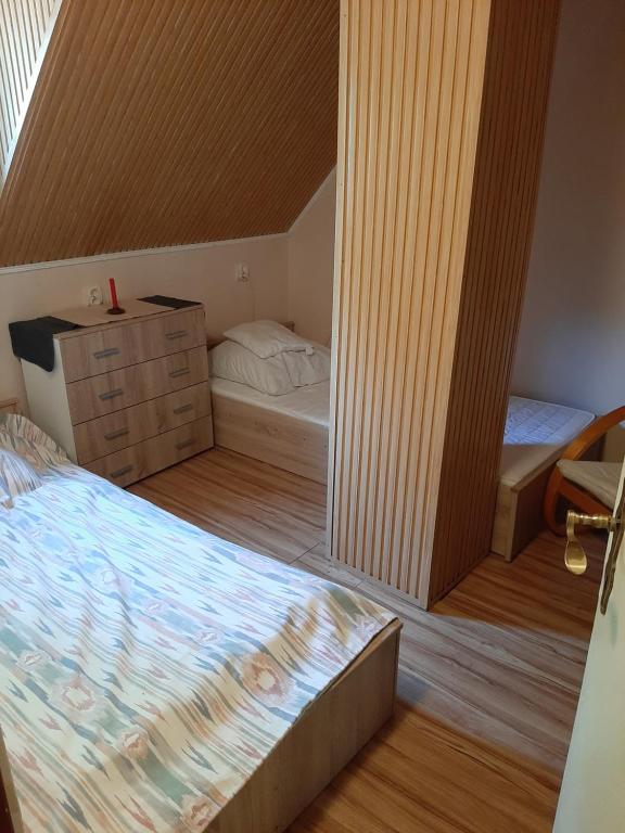 a small room with a bed and a dresser and a bedroom at Krémerház a Vendégház in Harkány