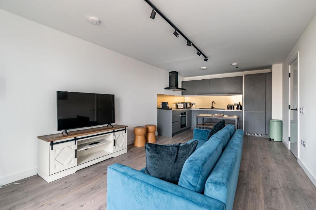 un salon avec un canapé bleu et une télévision dans l'établissement amazing apartments - Great Junction St - by Water of Leith, à Édimbourg
