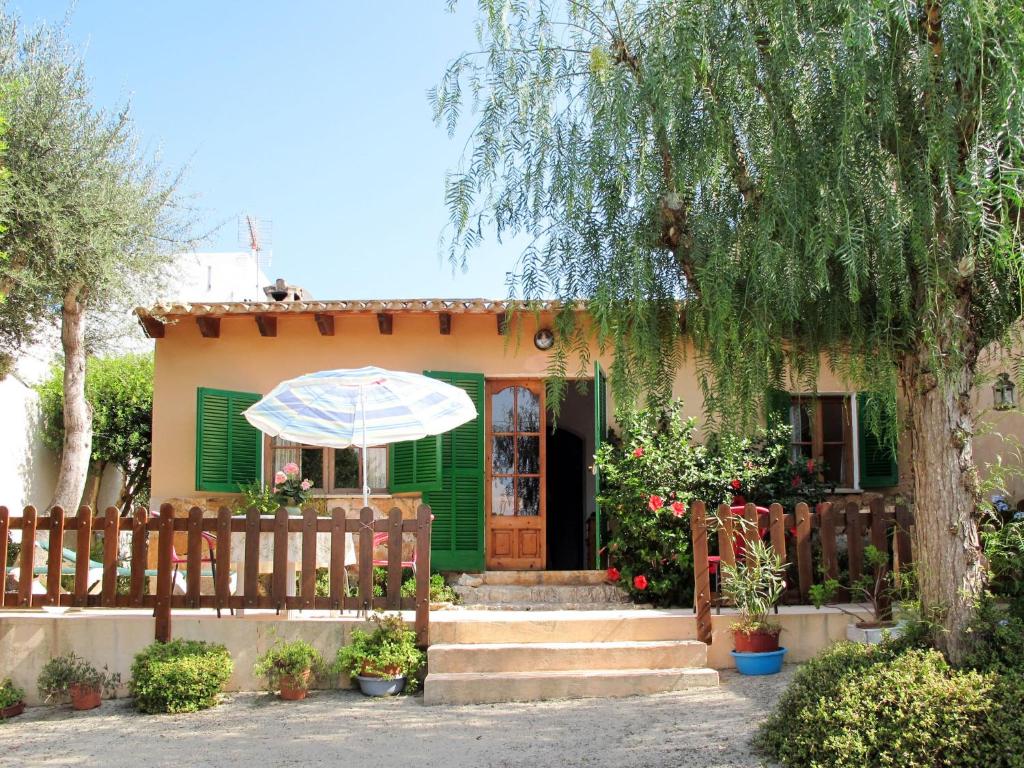 a house with a green door and a wooden fence at Holiday Home Sa Caseta by Interhome in Cala Santanyi