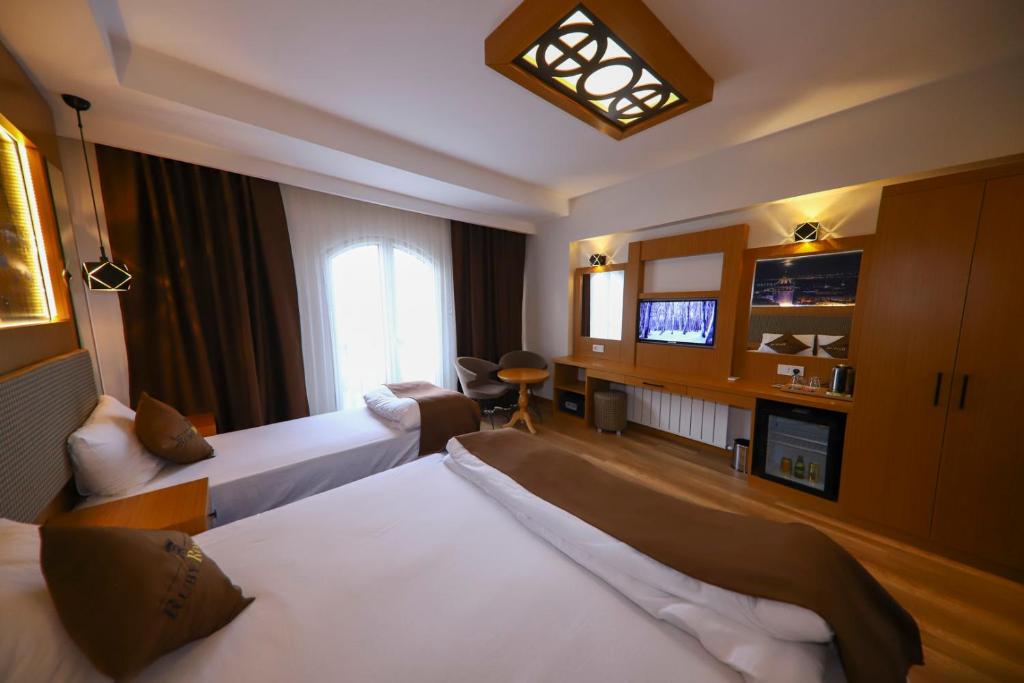 a hotel room with two beds and a television at Ruby Royal in Istanbul