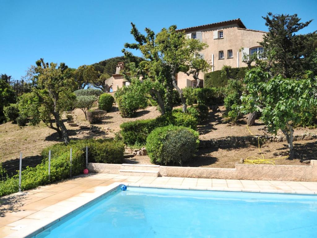 a swimming pool in front of a house with trees at Holiday Home Le Coba - MAX195 by Interhome in Sainte-Maxime