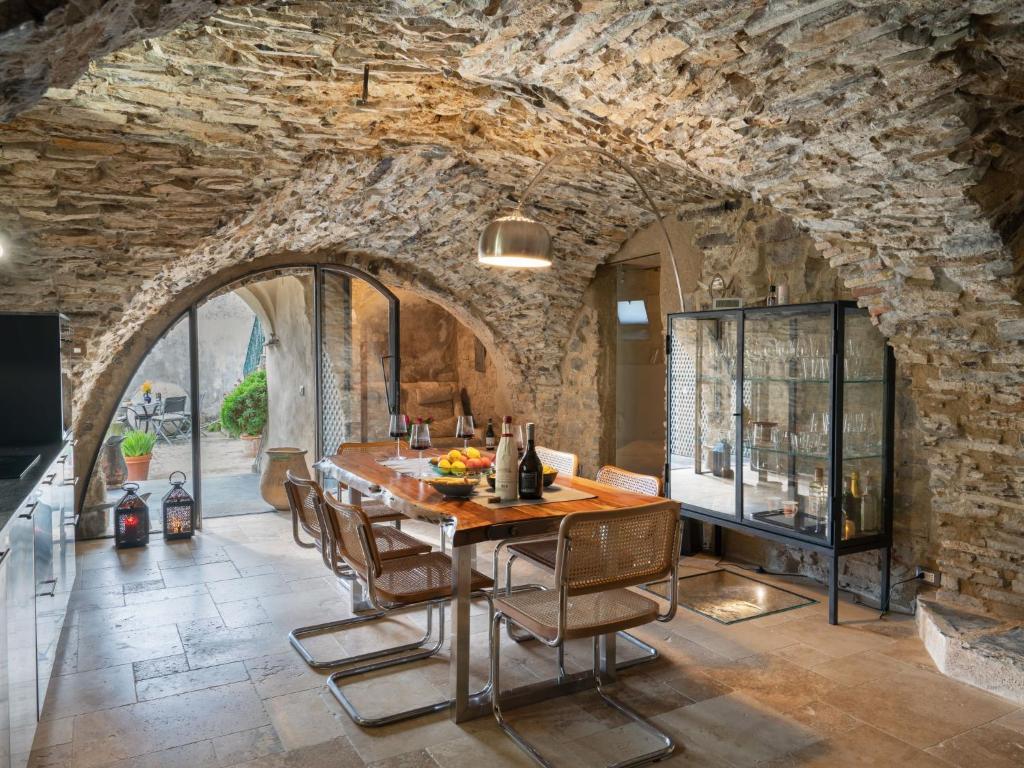 ein Esszimmer mit einer Steinmauer sowie einem Tisch und Stühlen in der Unterkunft Apartment Mulino by Interhome in Montegrazie