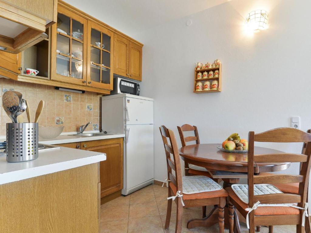 kuchnia ze stołem i krzesłami oraz białą lodówką w obiekcie Apartment Jadran-3 by Interhome w Nin
