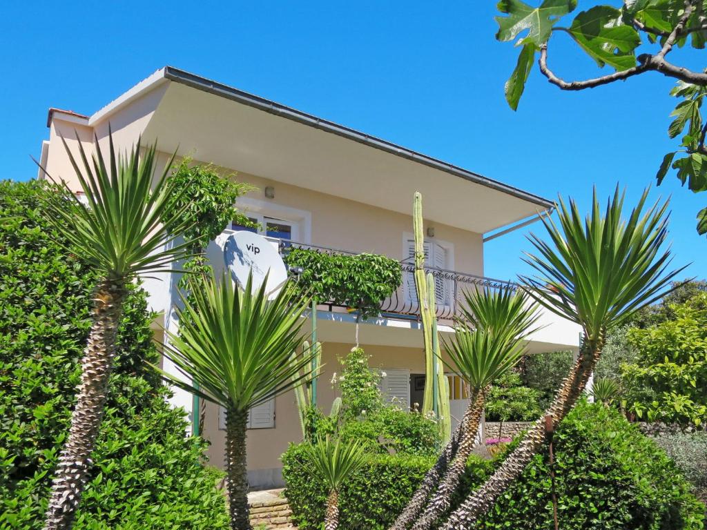 uma casa com palmeiras em frente em Holiday Home Maslina - TGR616 by Interhome em Voluja