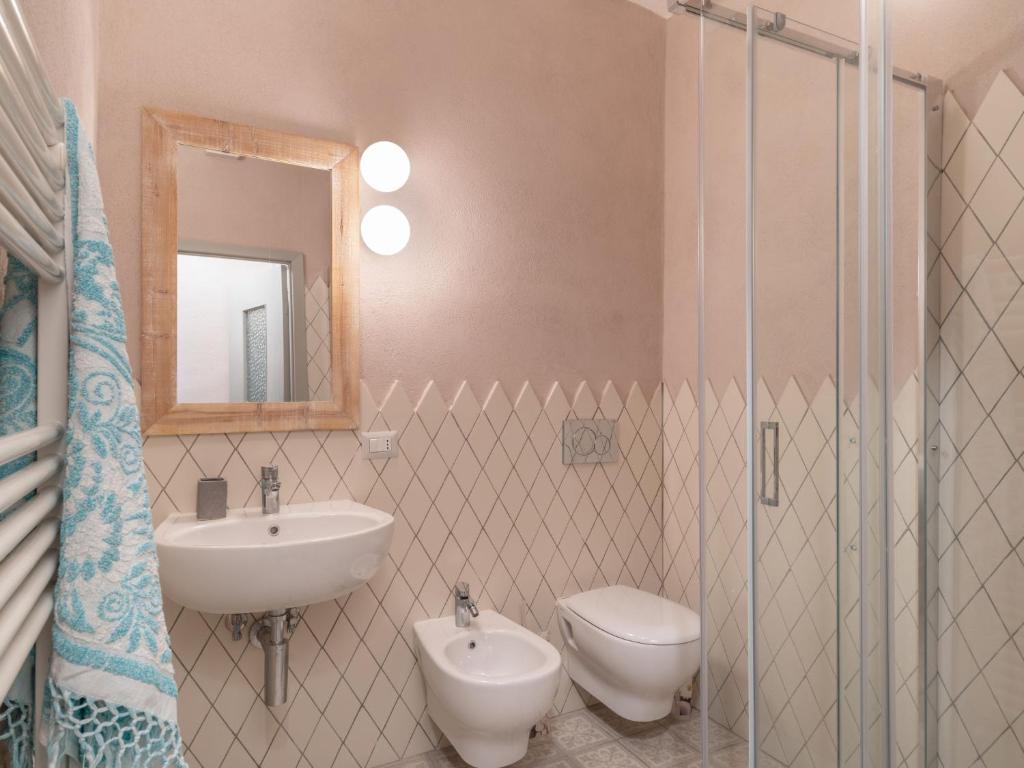 łazienka z umywalką, toaletą i lustrem w obiekcie Apartment Caruggiu - PTB193 by Interhome w mieście Pietrabruna