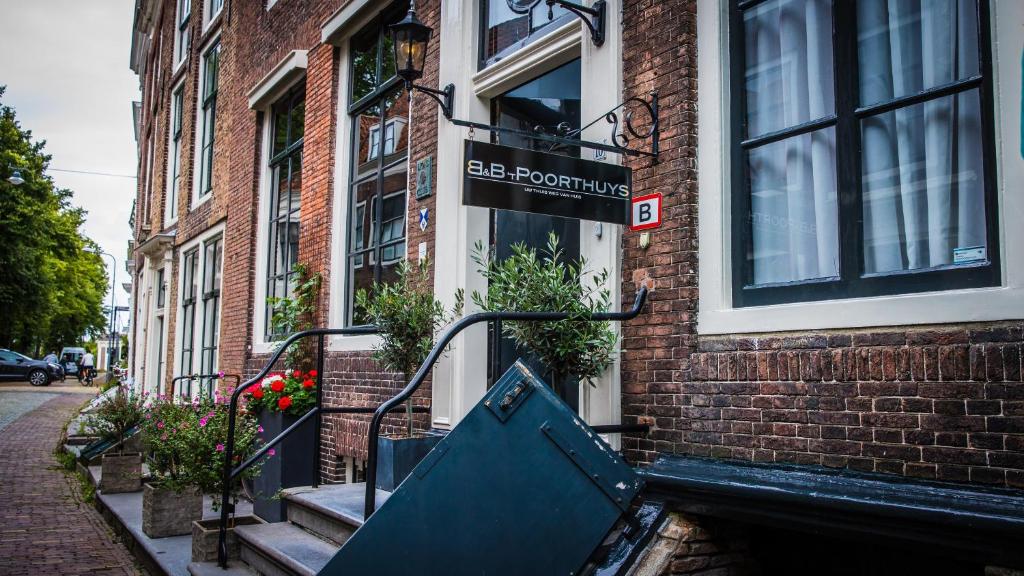 
a brick building with stairs leading to a balcony at B&B 't Poorthuys in Middelburg
