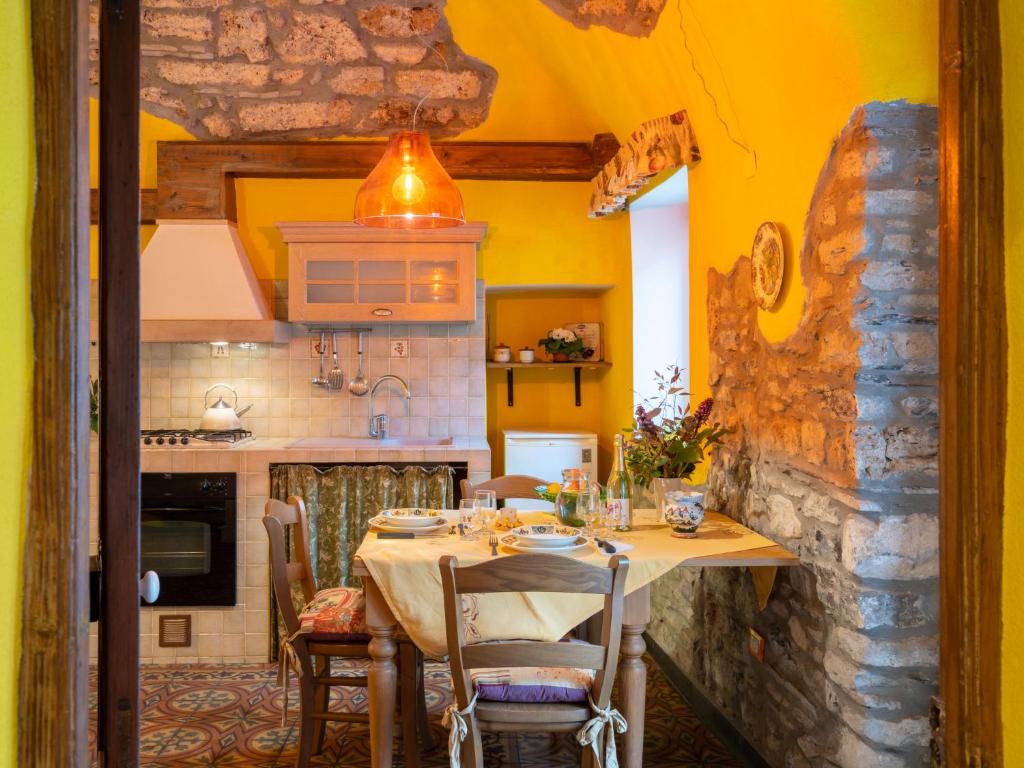a dining room with a table and a kitchen at Apartment Limone by Interhome in Dolcedo