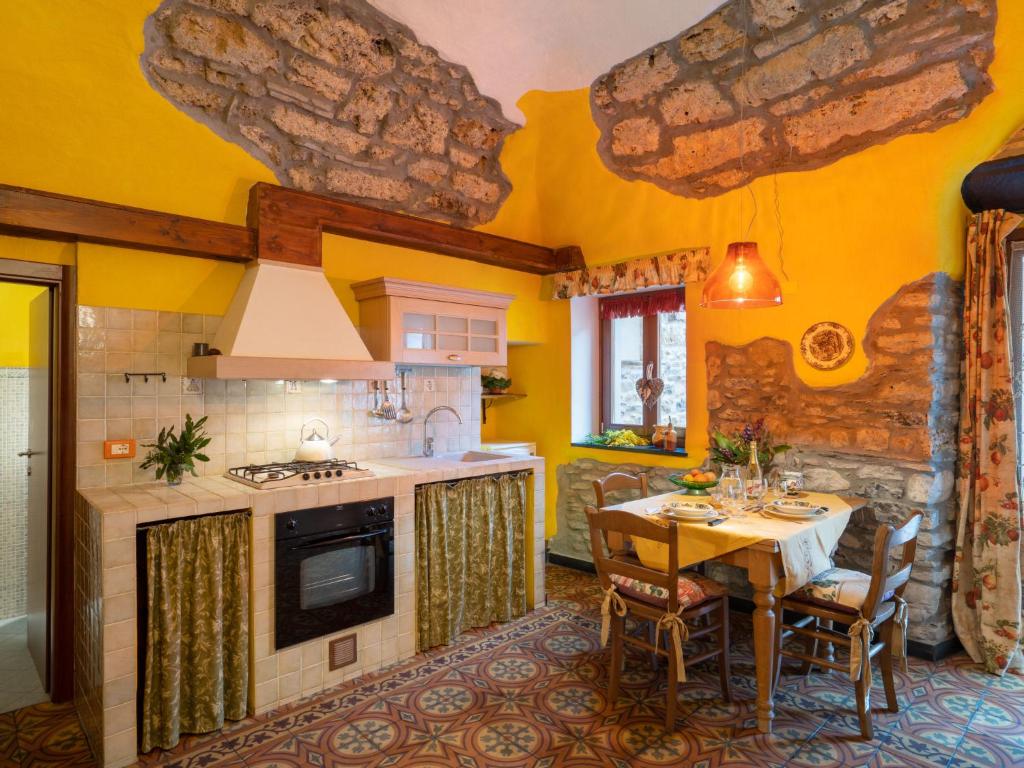 a kitchen with a dining table and a kitchen with yellow walls at Apartment Limone by Interhome in Dolcedo