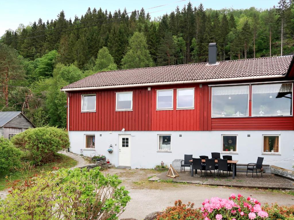 Casa roja y blanca con mesa y sillas en Apartment Mjellhaugen - FJS221 by Interhome, en Naustdal i Sunnfjord