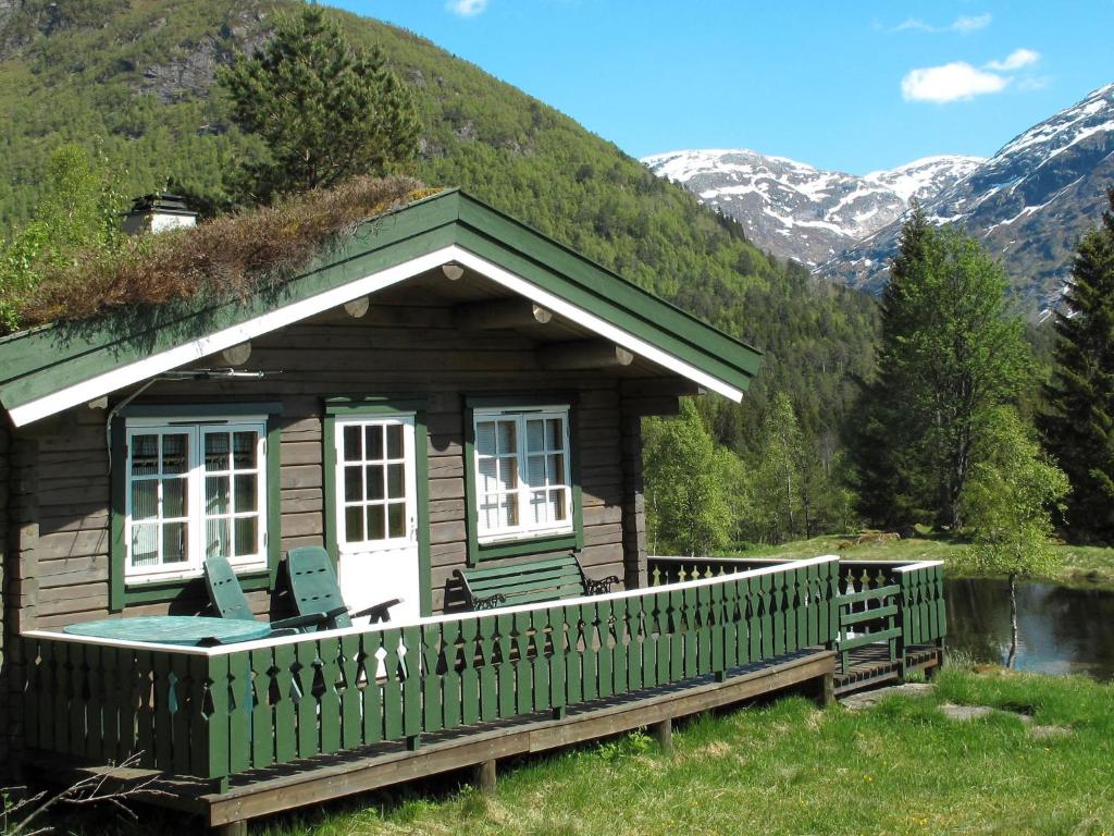 eine Blockhütte mit einem Grasdach und Stühlen auf der Veranda in der Unterkunft Chalet Fjellro - FJS103 by Interhome in Holsen