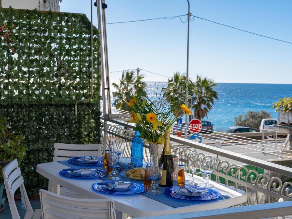 a table on a balcony with a view of the ocean at Apartment Casa Fidalma by Interhome in Costarainera