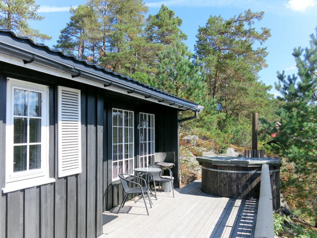 a house with a deck and a tub at Holiday Home Evabu - SOW069 by Interhome in Øyuvstad