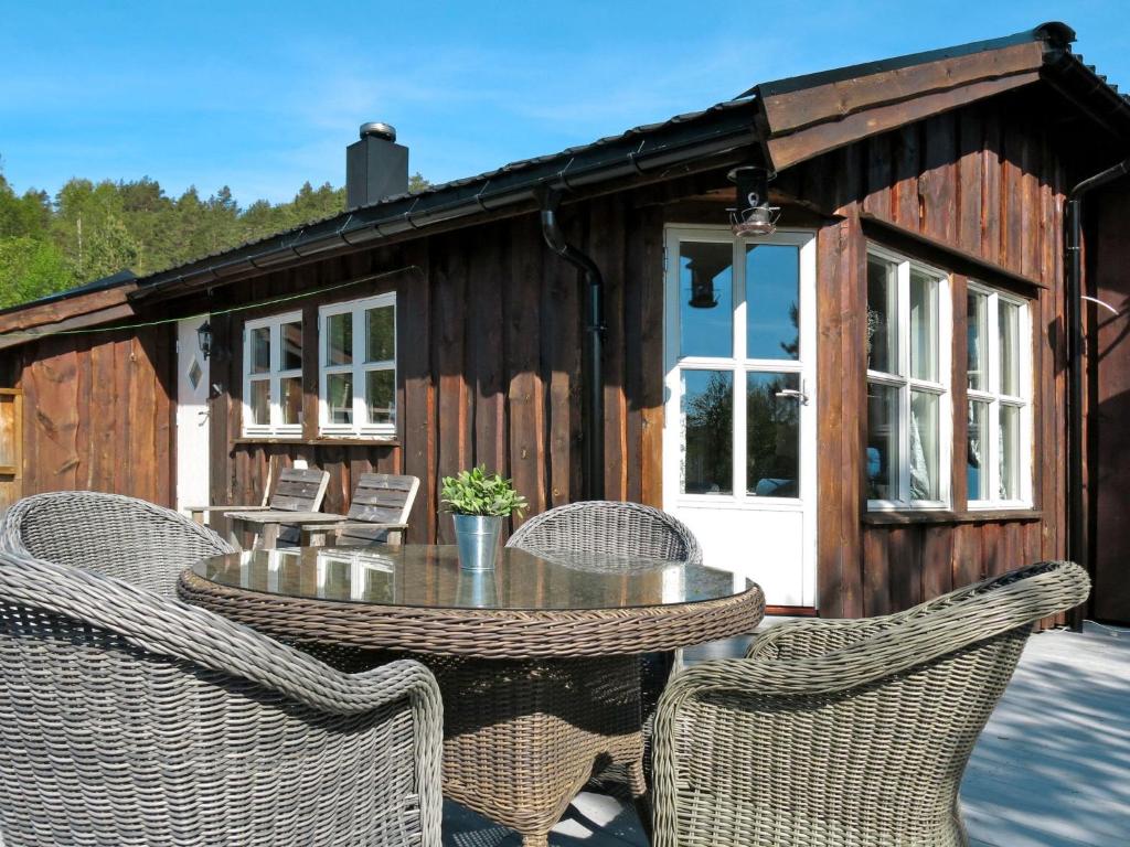un patio con mesa y sillas frente a una cabaña en Holiday Home Solfridbu - SOW070 by Interhome en Øyuvstad